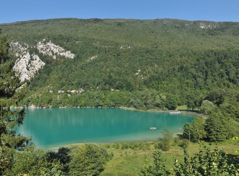 Une anse turquoise au pied d’une montagne boisée aux falaises blanches