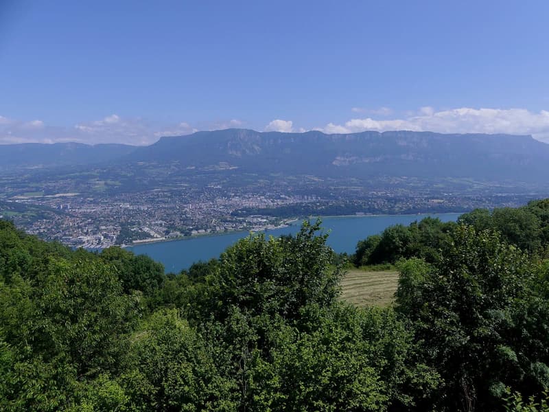 Le lac du Bourget et la ville d’Aix-les-Bains vus d’une hauteur, les Bauges au fond