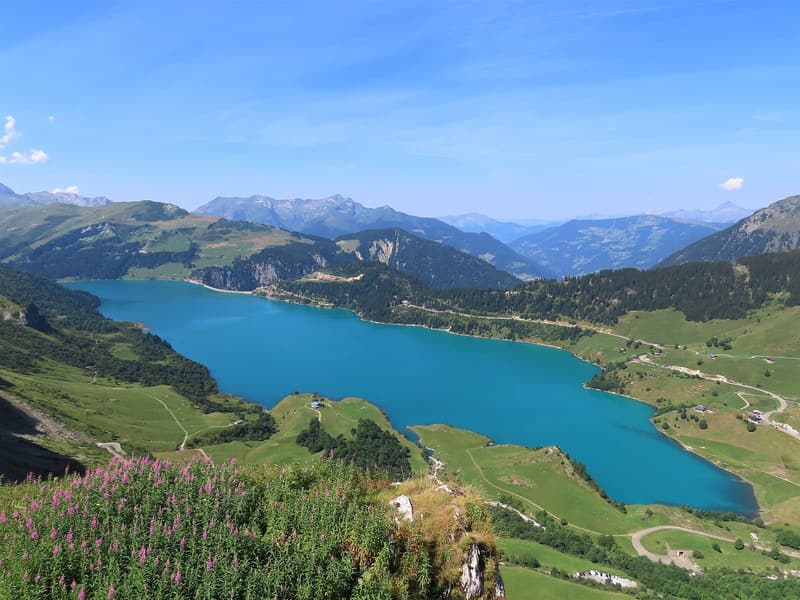 Le lac de Roselend bleu entre les alpages, vu d’en haut